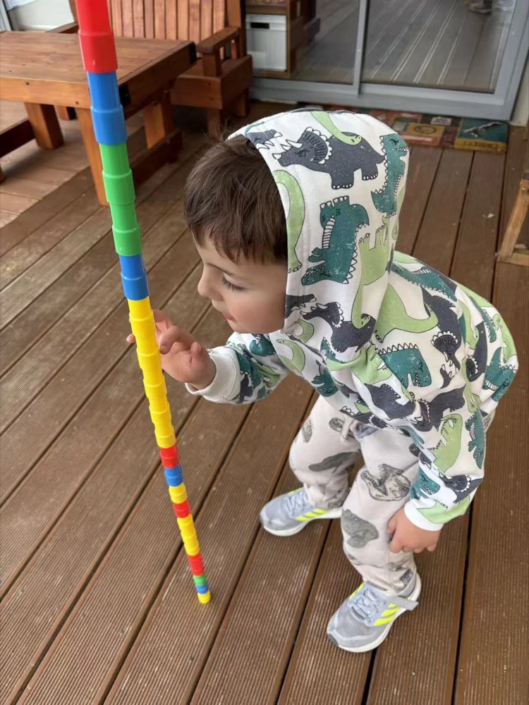 A child climbing on a colourful pole