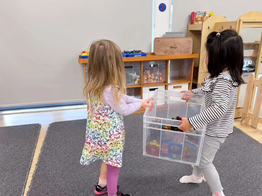 Two children tidying up together